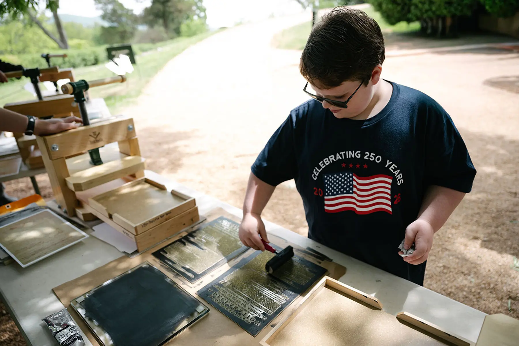 A boy is using the print shop to make his own printing of the declaration of independence.